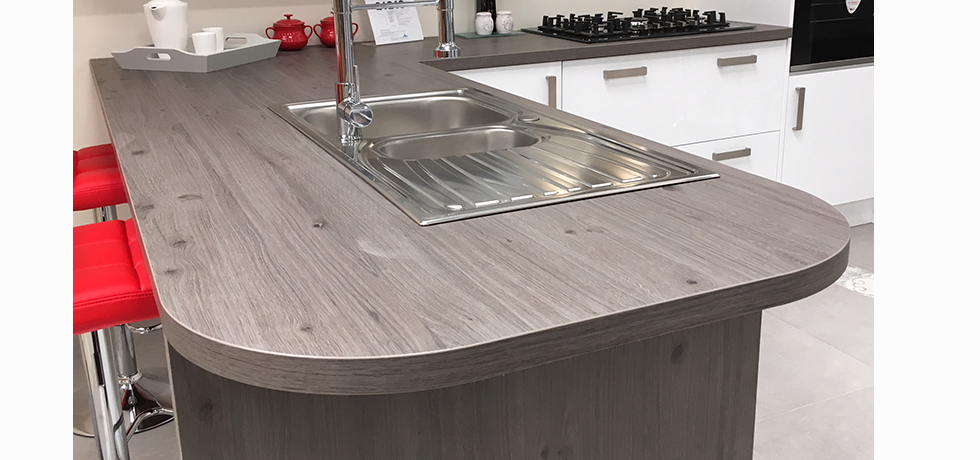 Worcester City Kitchens displaying an Omega Tocbacco Oak curved breakfast bar. 
